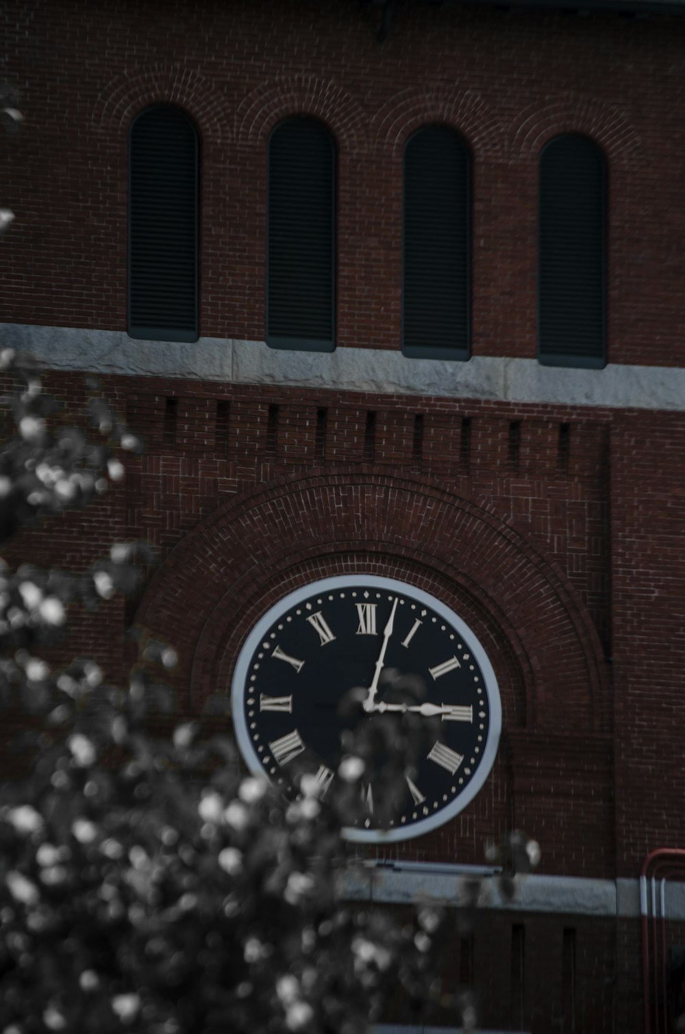 red and black analog clock at 11 00