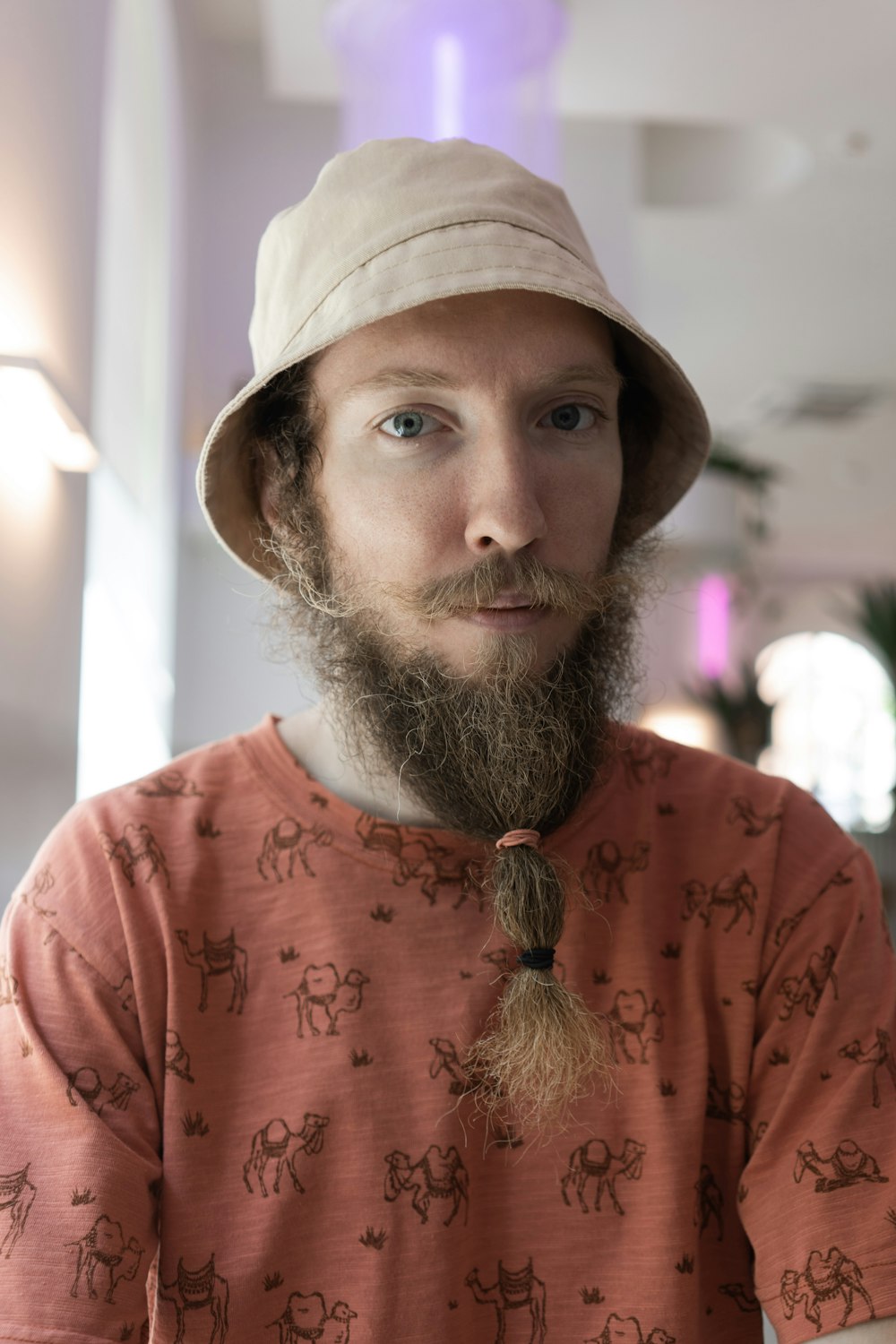 man in orange crew neck shirt wearing brown hat