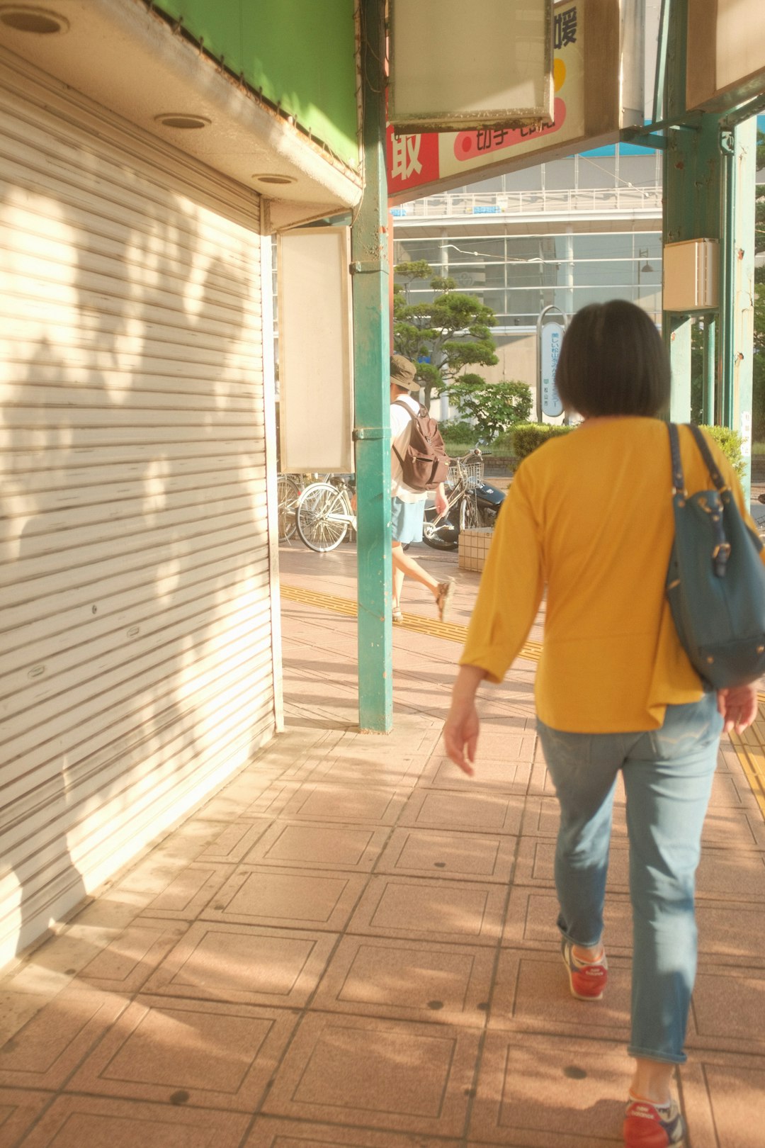 woman in yellow shirt and blue denim jeans walking on brown wooden floor