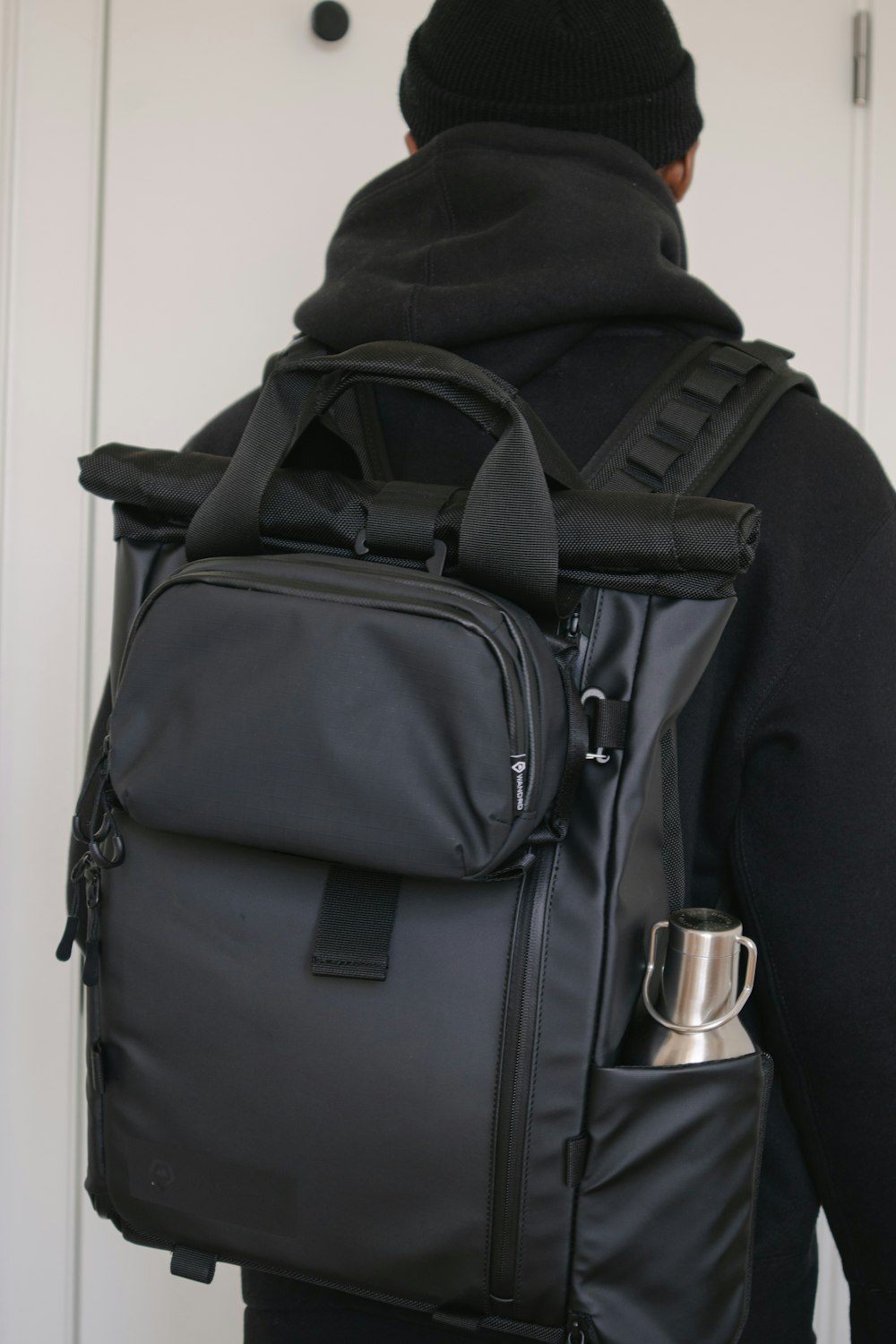 black backpack on white wooden door