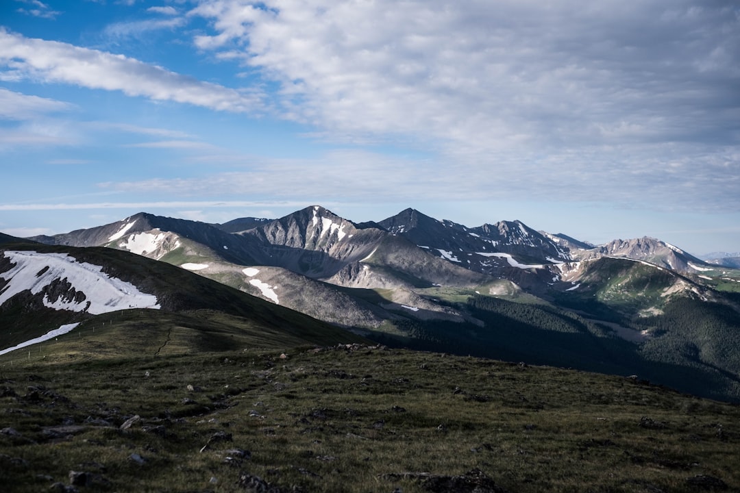 snow covered mountains under cloudy sky during daytime