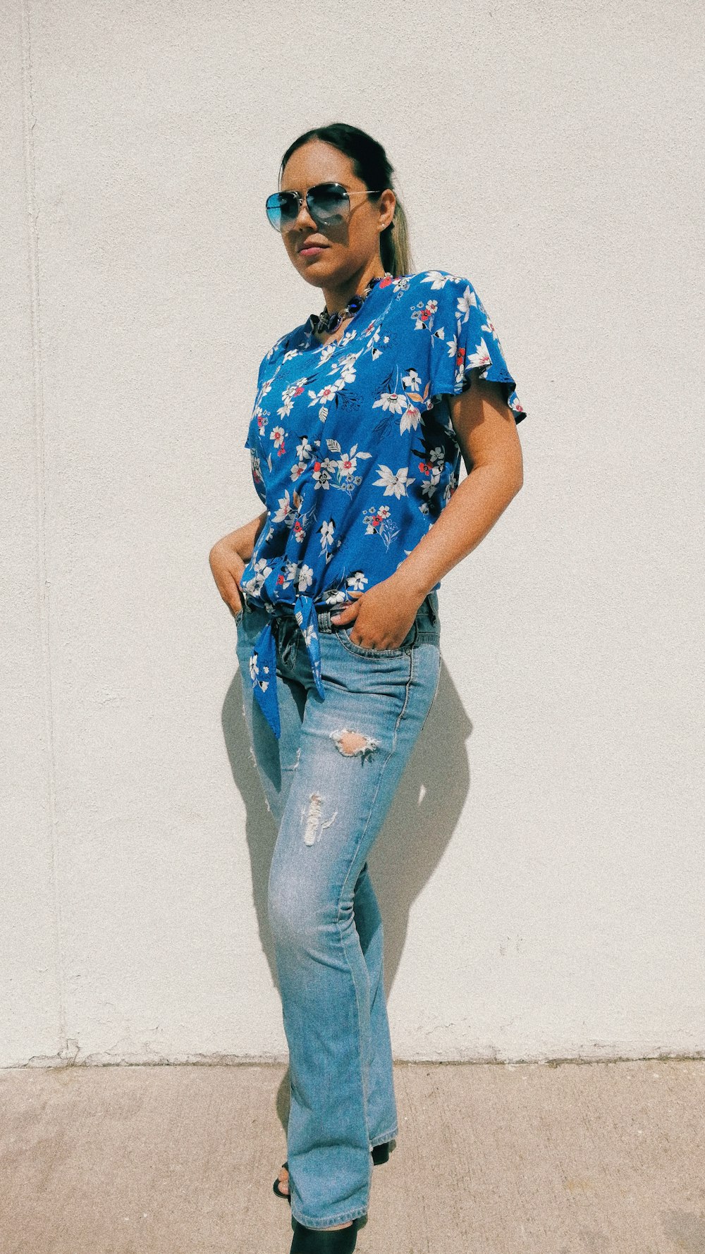 woman in red blue and white floral shirt and blue denim jeans