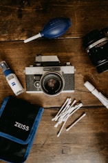 black and silver dslr camera beside white and black disposable lighter