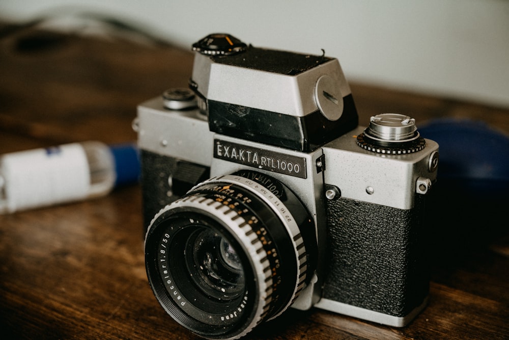 black and silver nikon dslr camera on brown wooden table