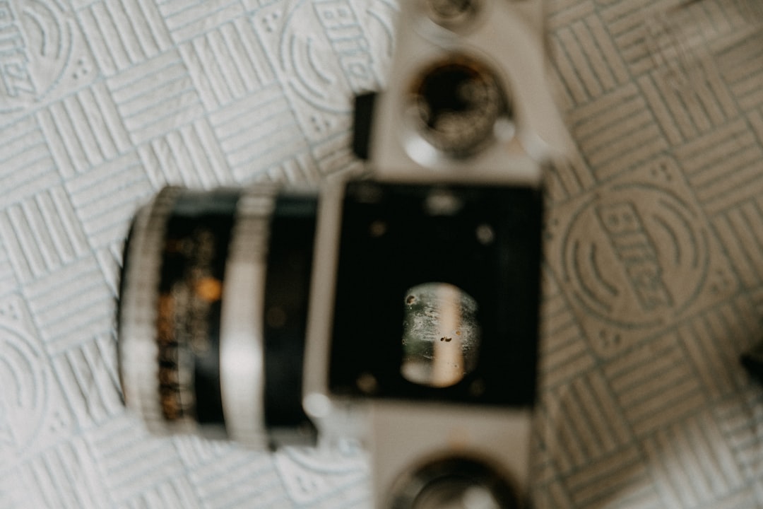 black and silver camera on white textile