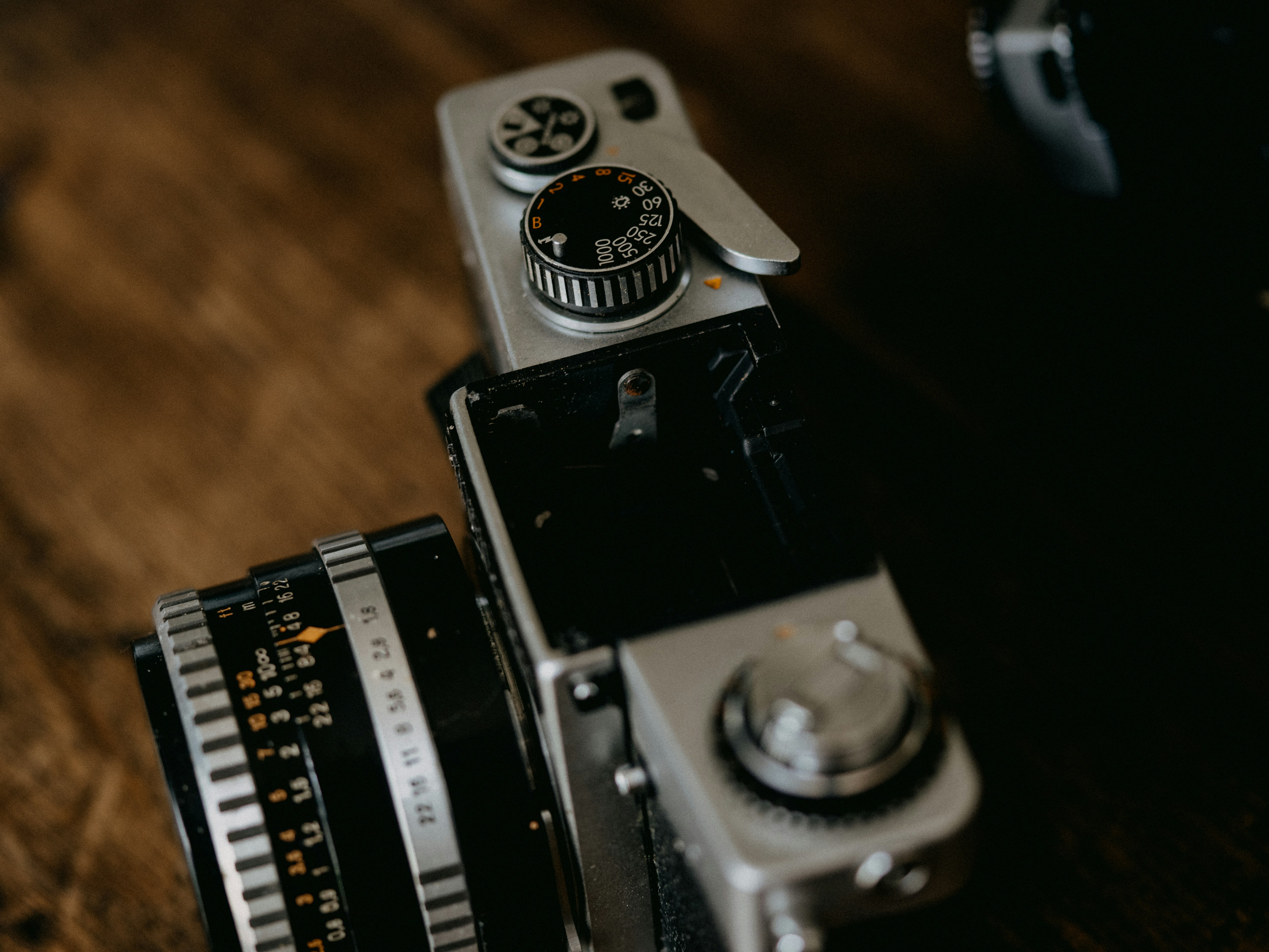 black and silver camera on brown wooden table