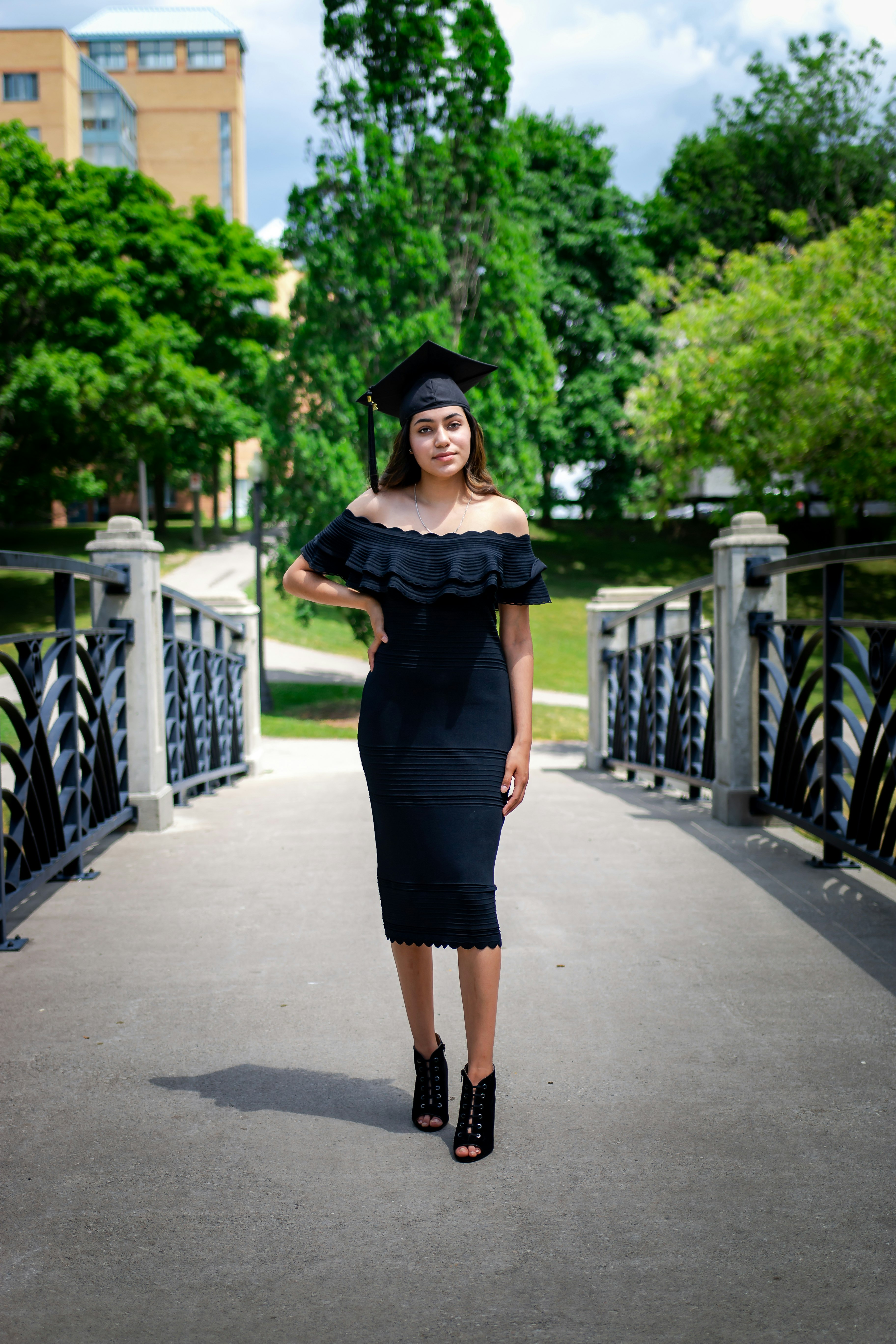 woman in black dress standing on gray concrete pathway during daytime