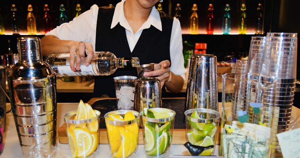 homme en veste de costume blanc tenant une tasse en verre transparent