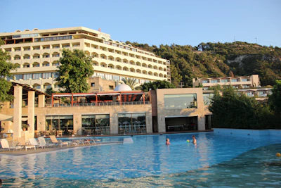 A sparkling outdoor pool with guests enjoying a sunny day at Sonar Bangla Hotel.