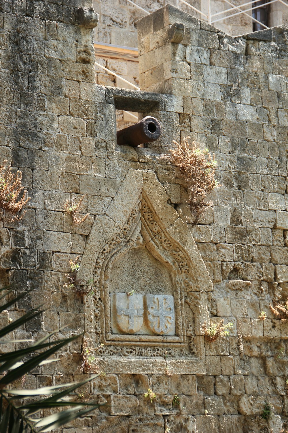 brown wooden cross on brown brick wall