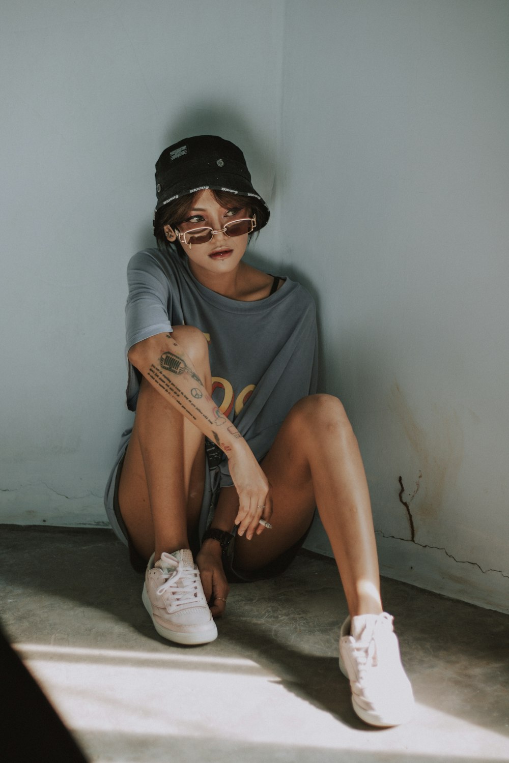 woman in gray crew neck t-shirt wearing black sunglasses and brown leather boots