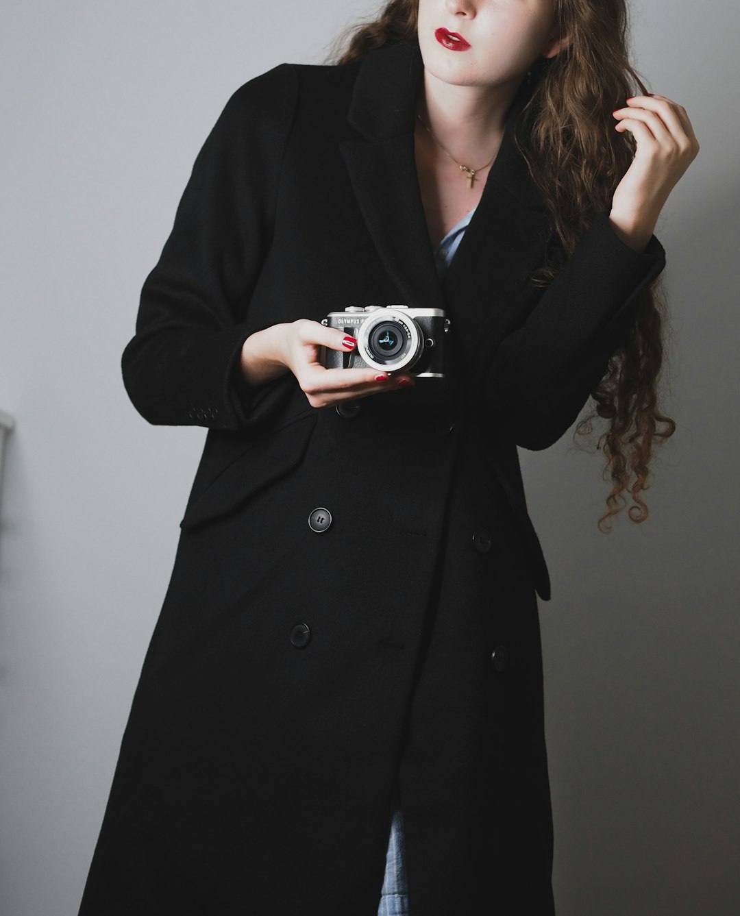 woman in black coat holding camera