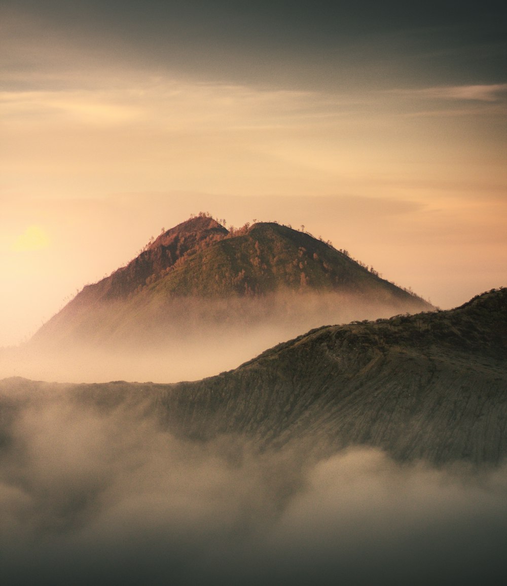 Brauner Berg tagsüber unter weißen Wolken