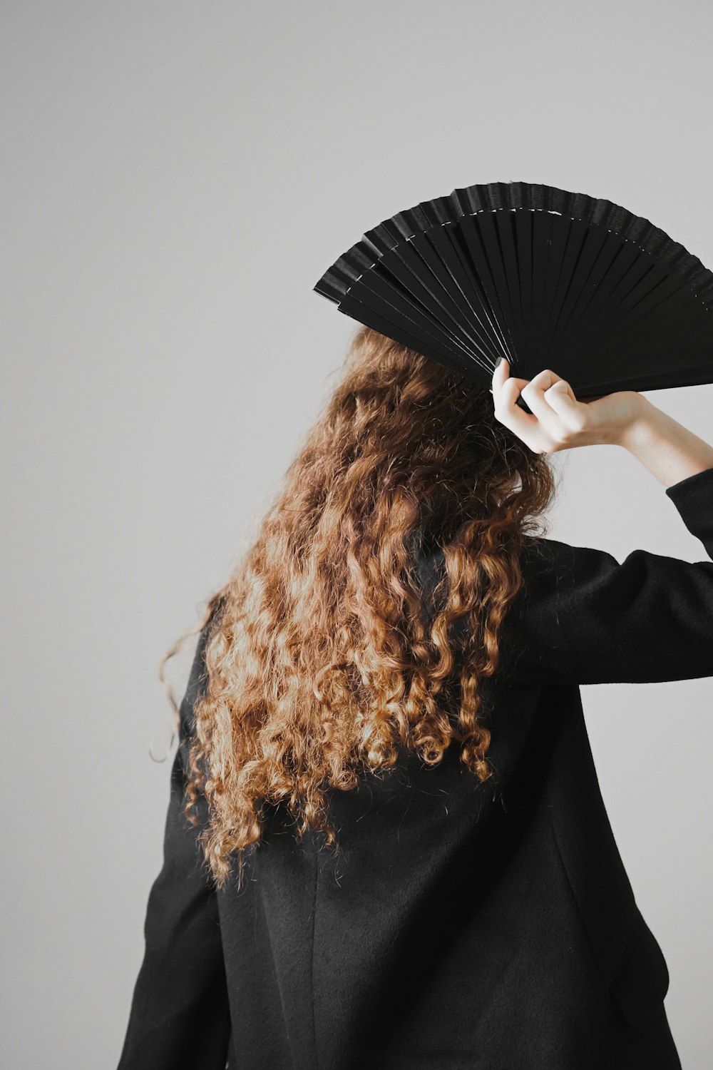 woman in black long sleeve shirt holding black umbrella