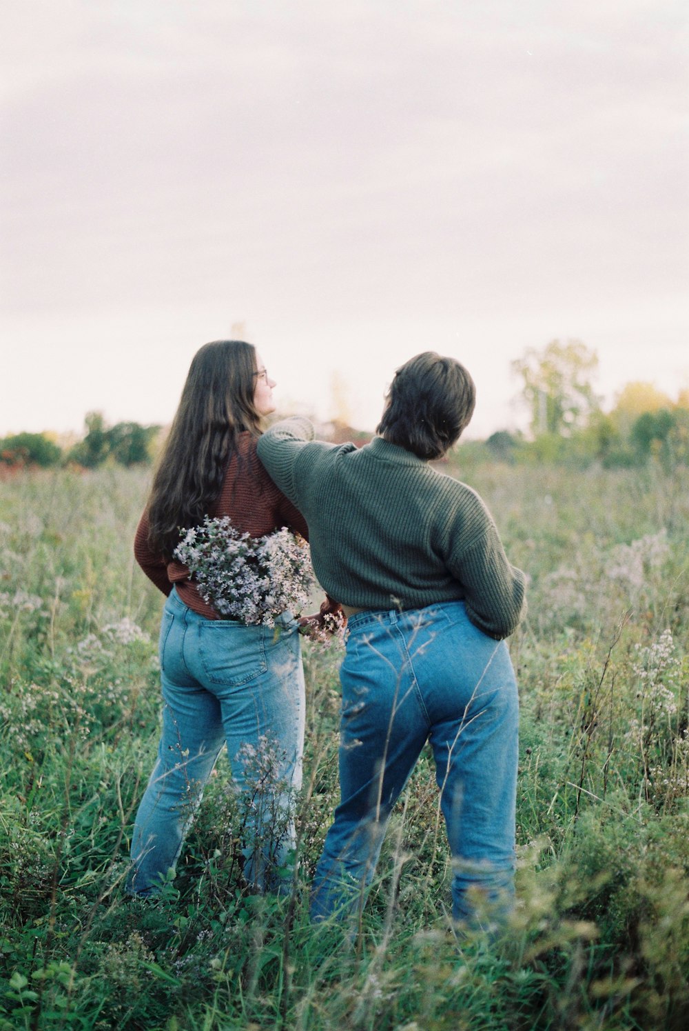 couple kissing on green grass field during daytime