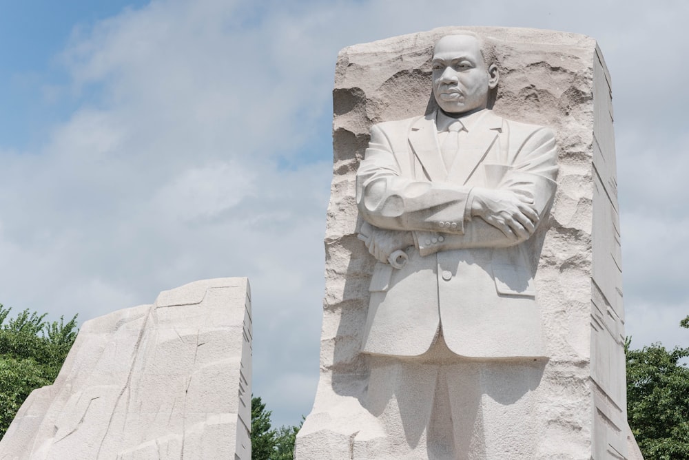 Estatua de hormigón blanco bajo el cielo azul durante el día