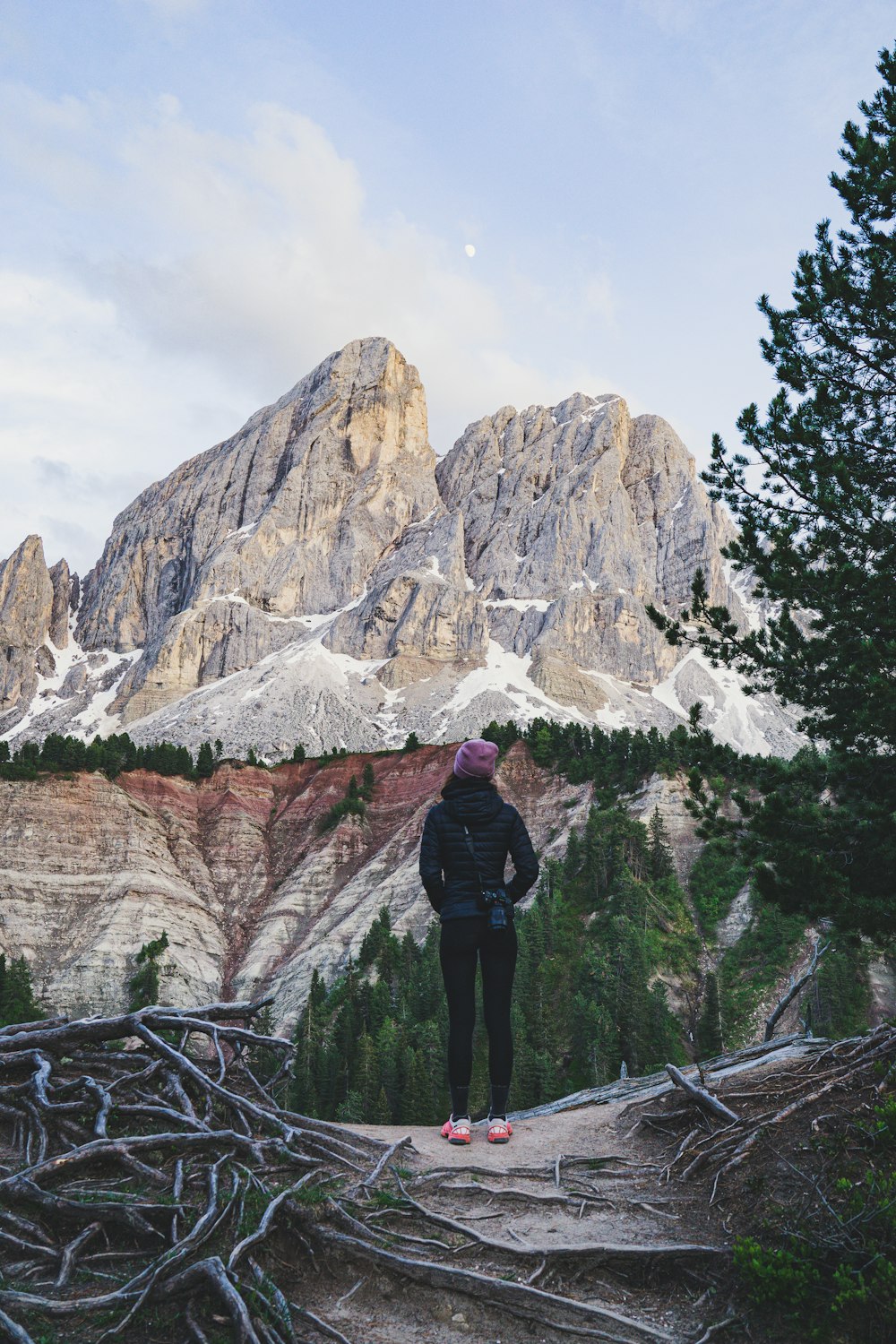 person in black jacket standing near mountain during daytime