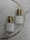 Two white bottles with gold caps are placed on a marble surface. The bottles have the label 'BEAUTYRAENA' and mention a drying time of 1-2 seconds. A thin gold curved line is present in the background.