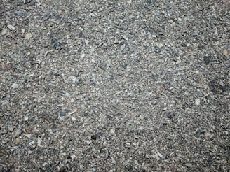 Close-up of a pothole with exposed gravel and broken pavement edges