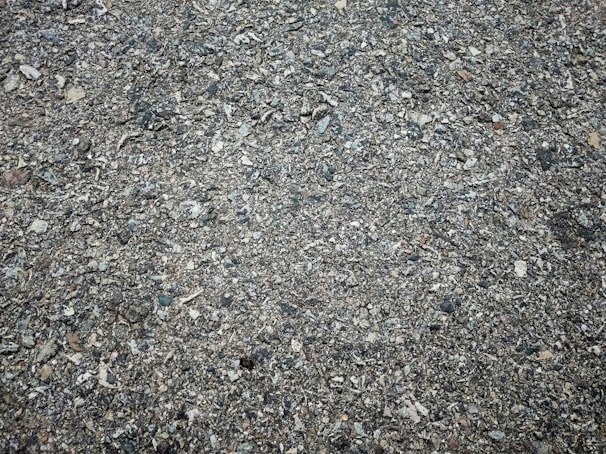 Close-up of a pothole with exposed gravel and broken pavement edges