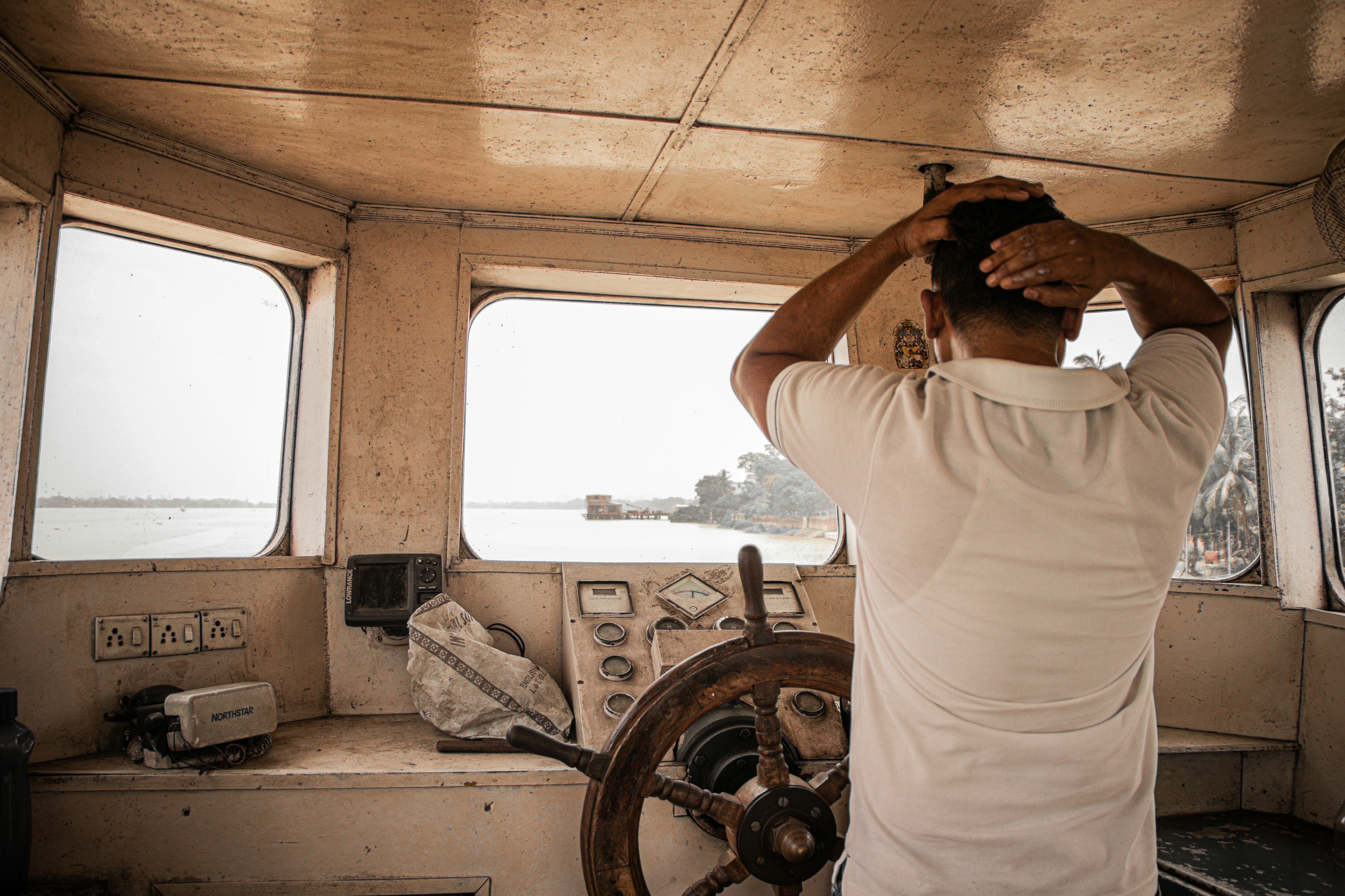 man in white t-shirt holding steering wheel