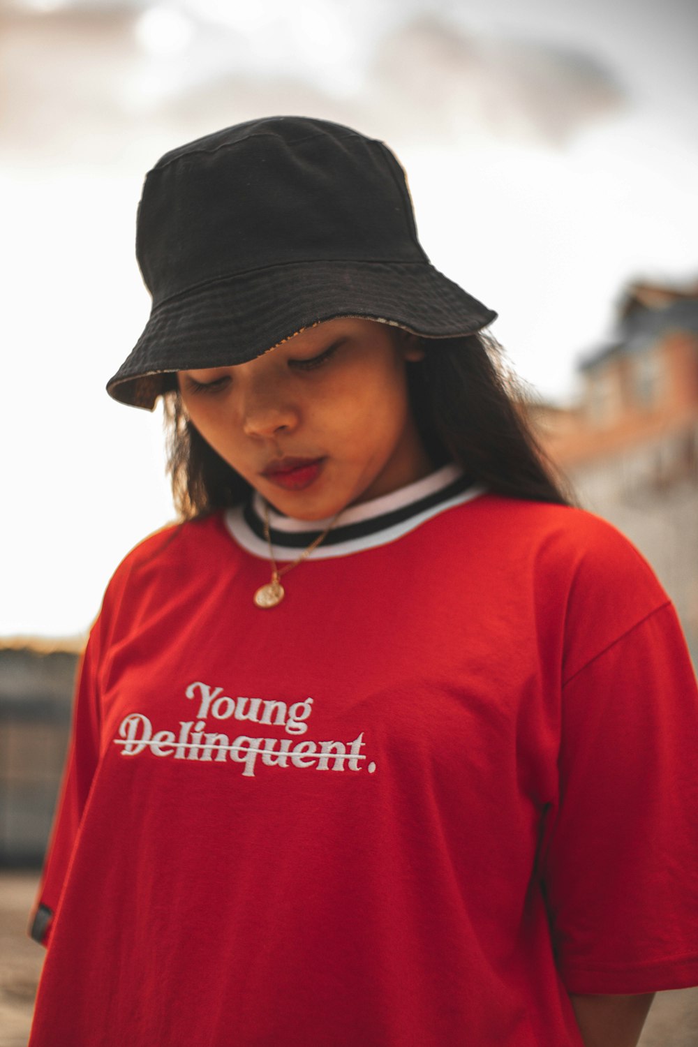 woman in red and white sweater wearing black hat