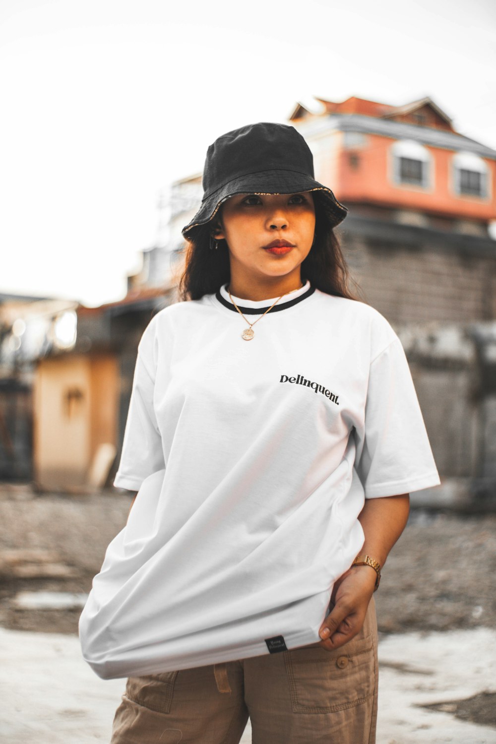 woman in white crew neck t-shirt and black cap standing on street during daytime