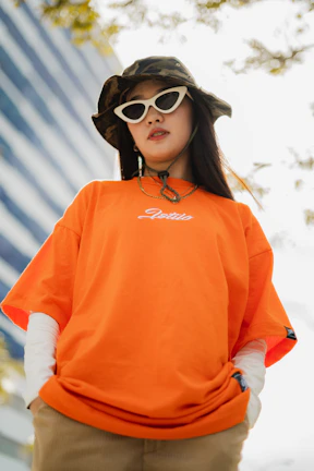 Dynamic streetwear look with a model wearing a white t-shirt customized with vibrant orange accents.