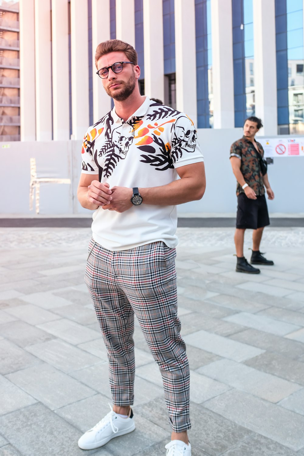 man in white blue and red plaid button up t-shirt and black and white pants