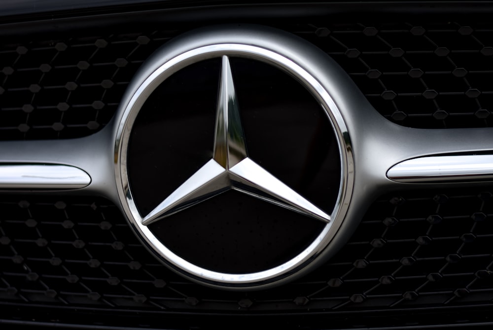 silver mercedes benz emblem on black car