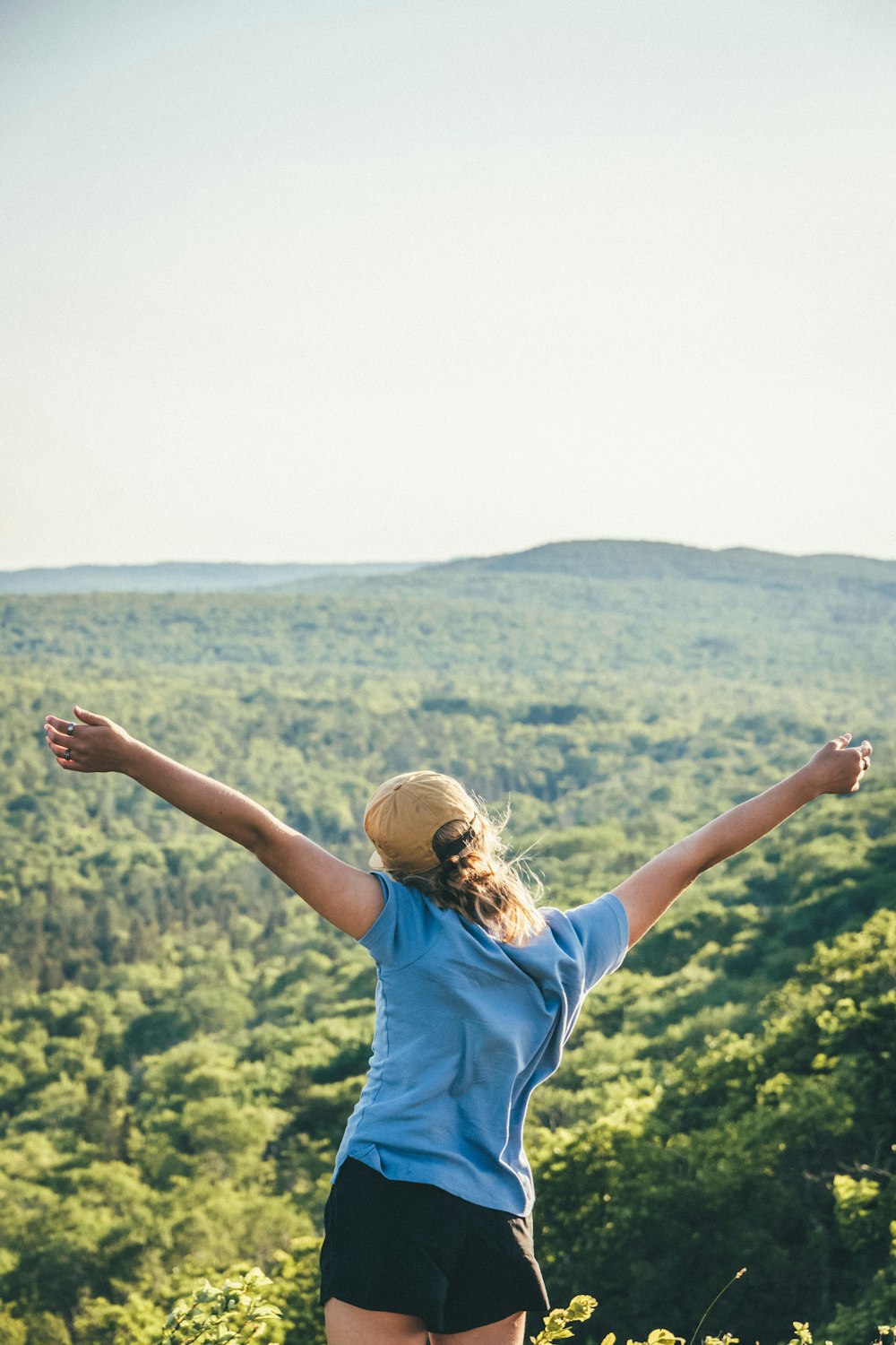 woman in blue t-shirt raising her hands