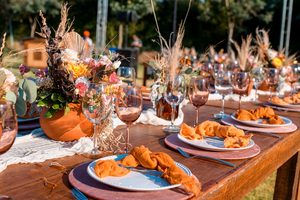 orange and white ceramic plate with clear wine glasses on brown wooden table