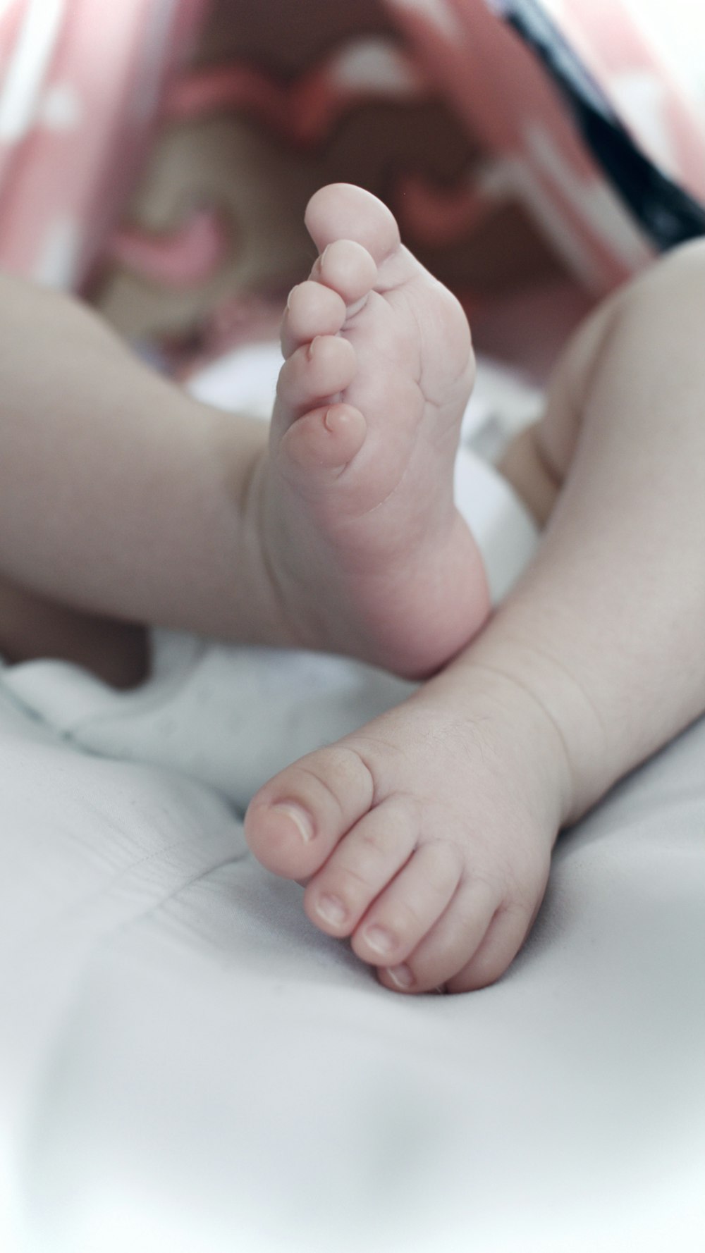 babys feet on white textile