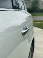 Before and after comparison of a car door showing detailed cleaning and waxing results