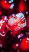 Close-up of ripe pomegranate seeds glistening under market lights.