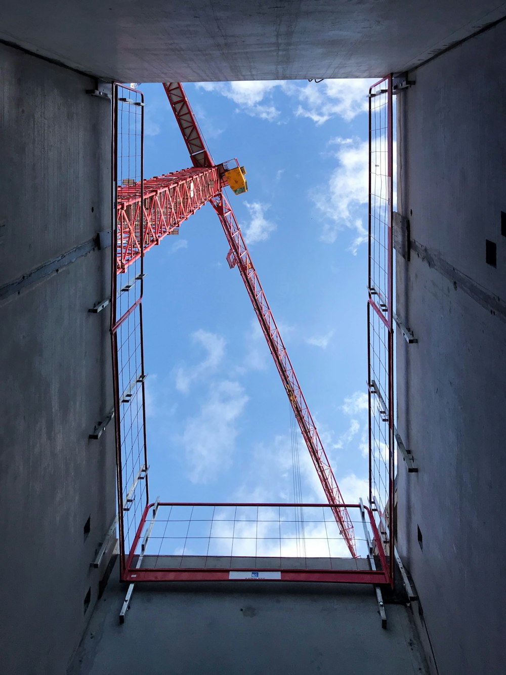 orange crane on gray concrete wall during daytime