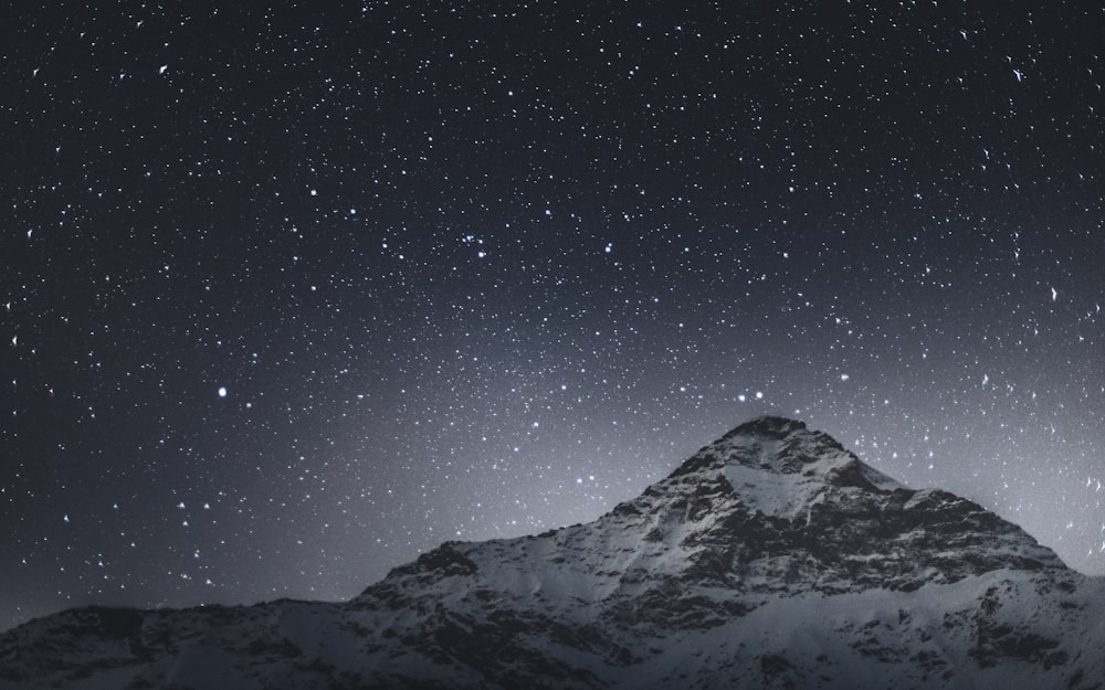 snow covered mountain under starry night