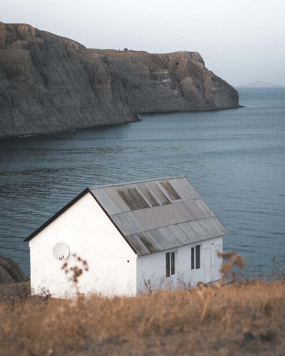 white and brown wooden house near body of water during daytime