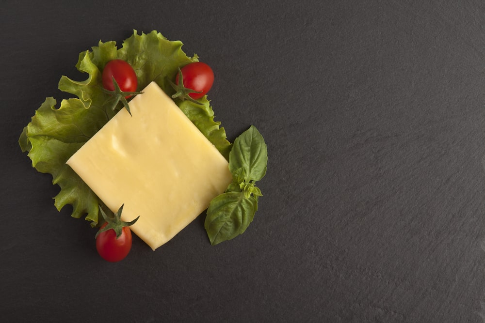 white cheese and red cherry on green leaves