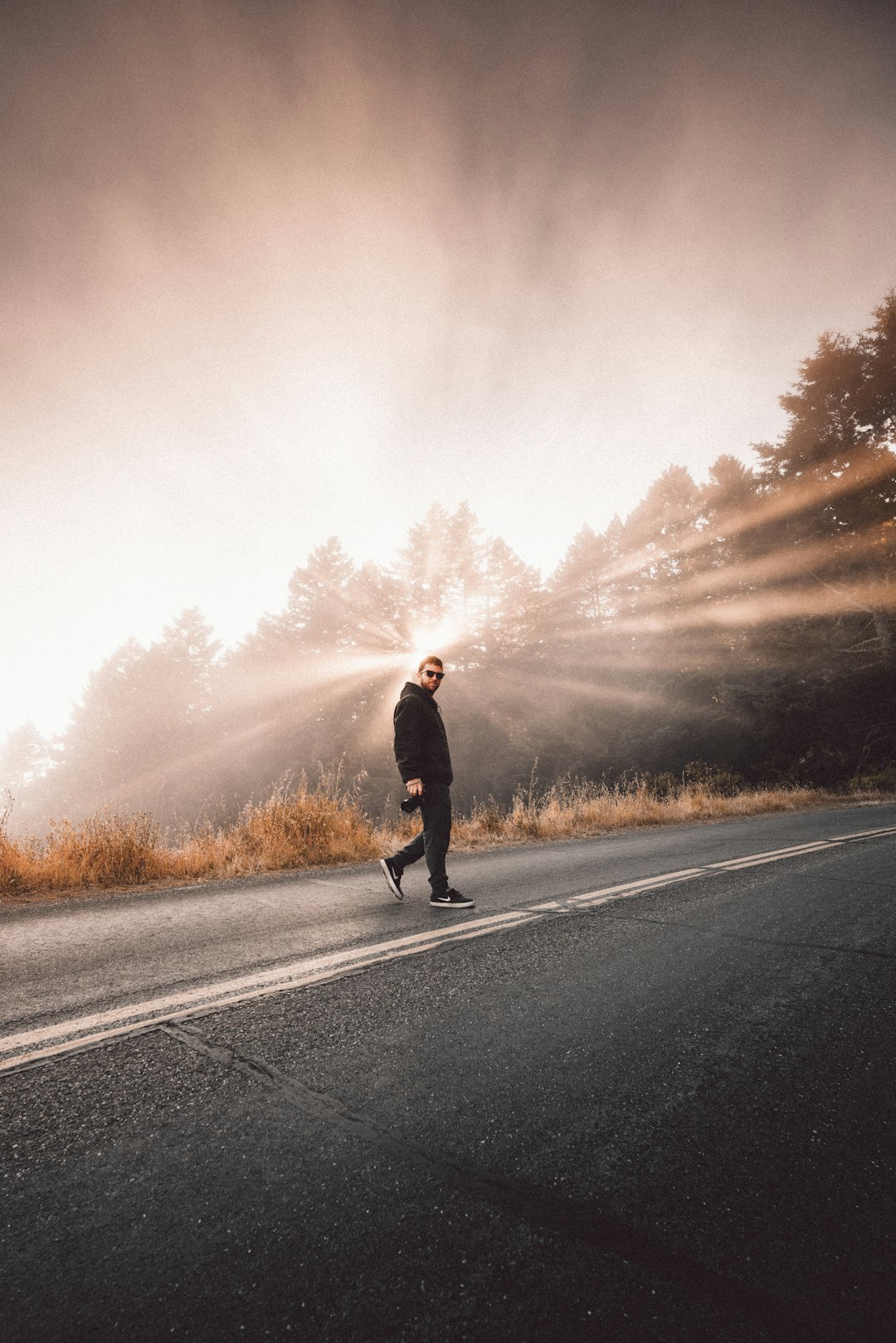 man in black jacket standing on road during daytime