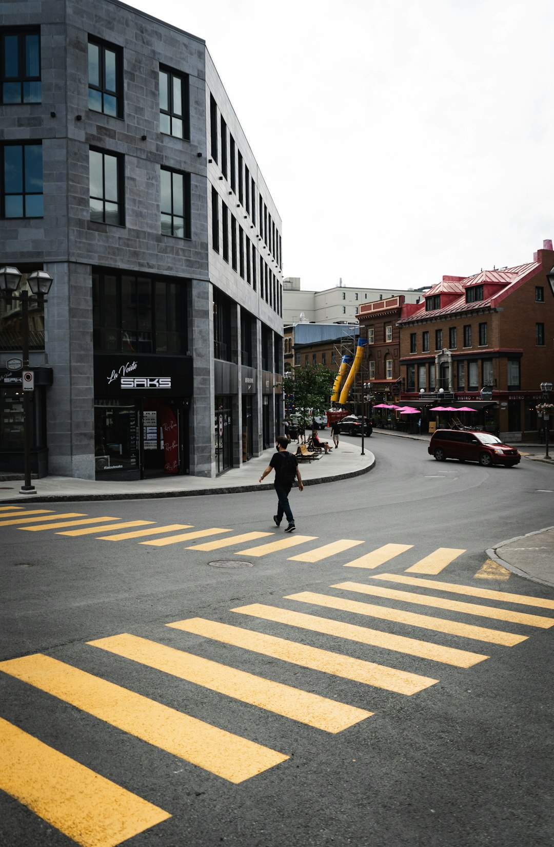 woman in black jacket walking on pedestrian lane during daytime