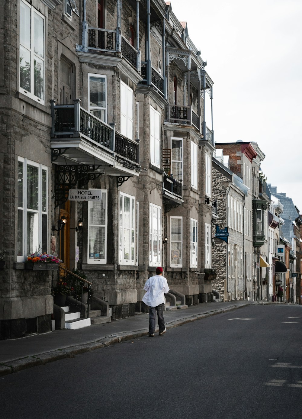 woman in white long sleeve shirt walking on sidewalk during daytime