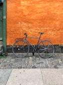Sleek urban commuter bike with a matte black frame parked against a city wall.