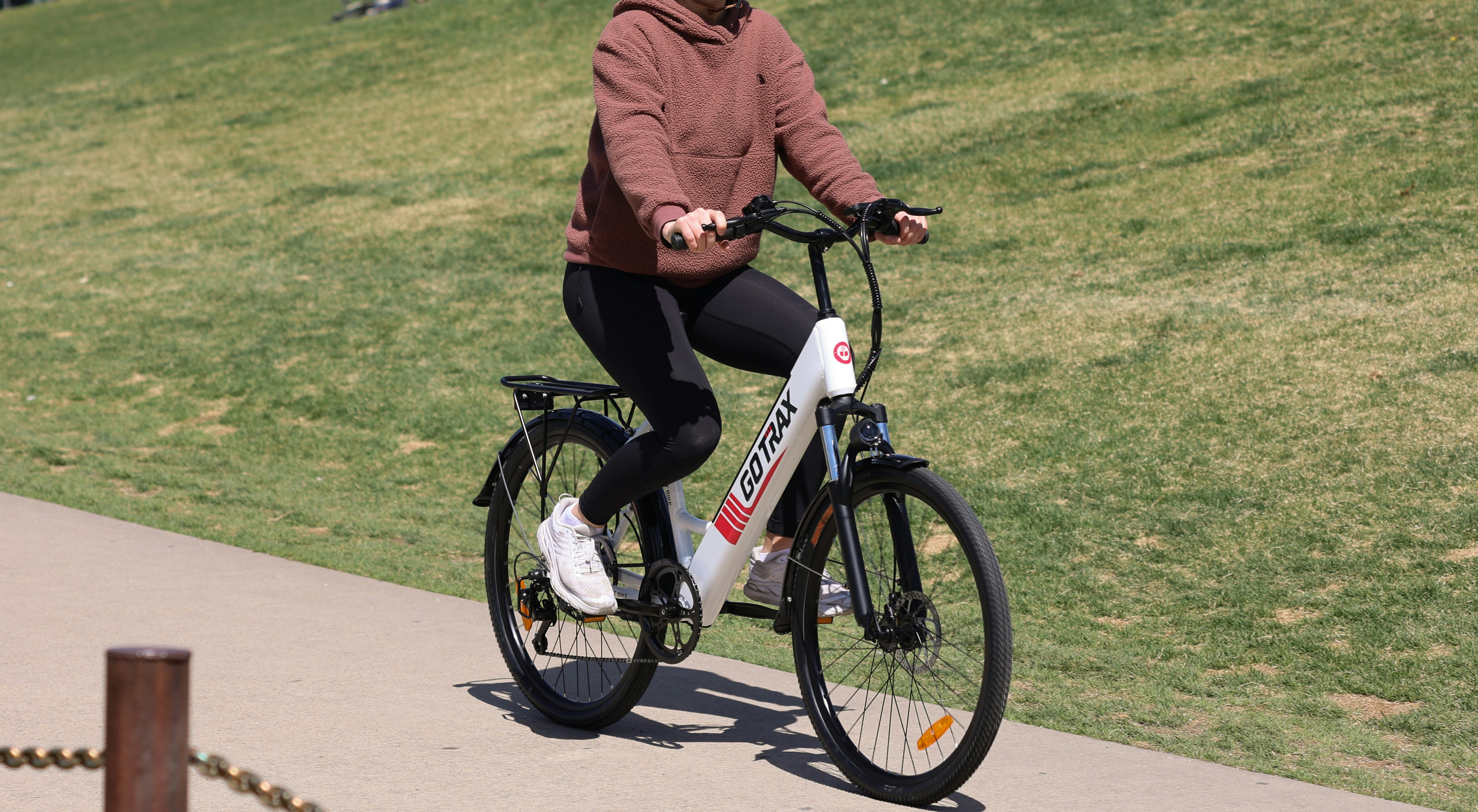 man in red jacket and black pants riding on red and white bicycle during daytime