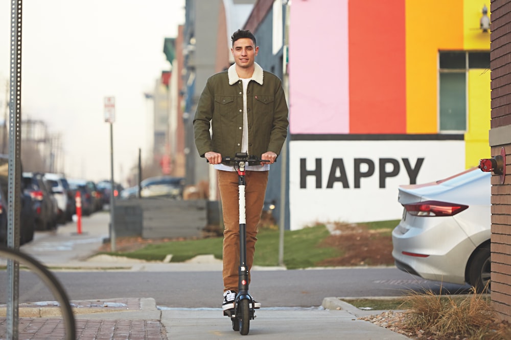 man in green blazer standing on sidewalk during daytime