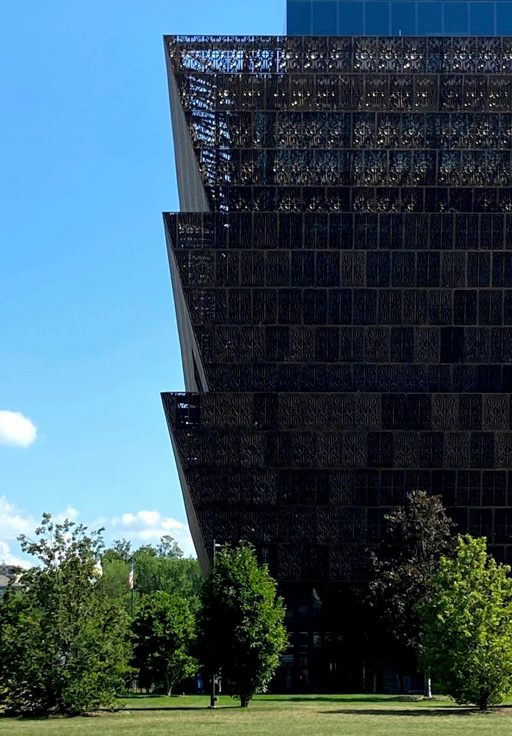 edificio in cemento nero vicino agli alberi verdi durante il giorno