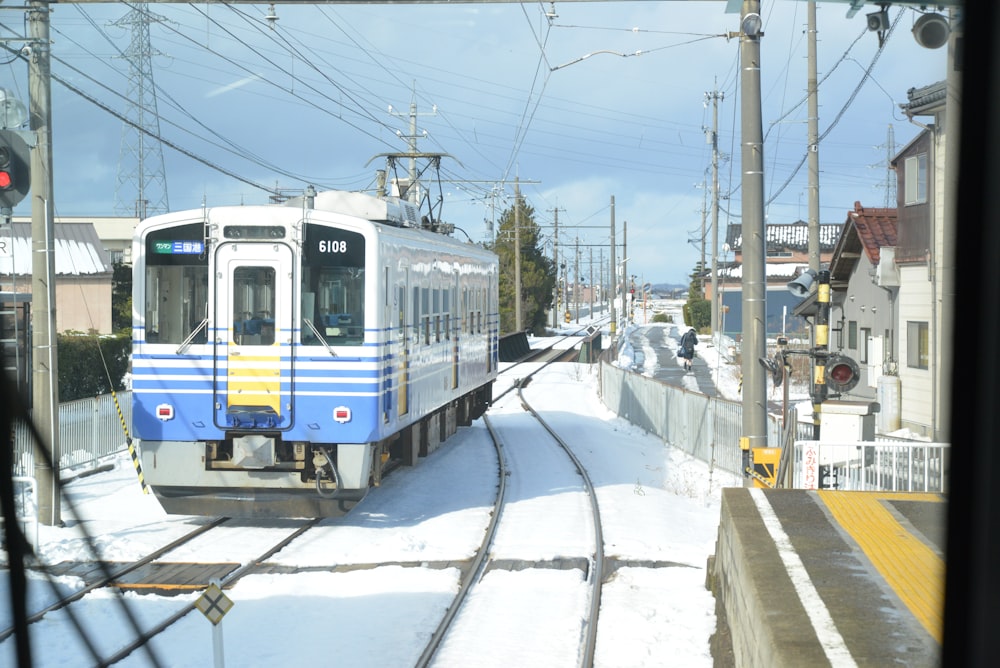 blue and white train on rail tracks during daytime