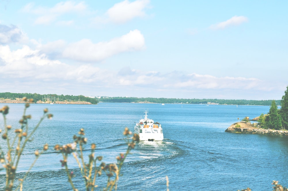 white boat on sea under blue sky during daytime