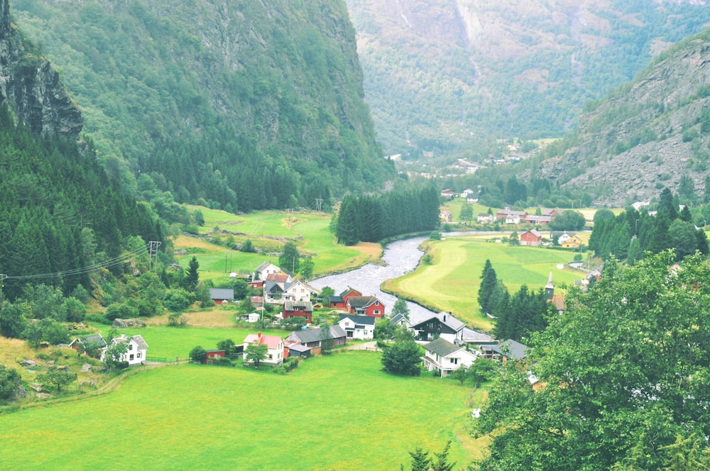 green grass field near green mountains during daytime