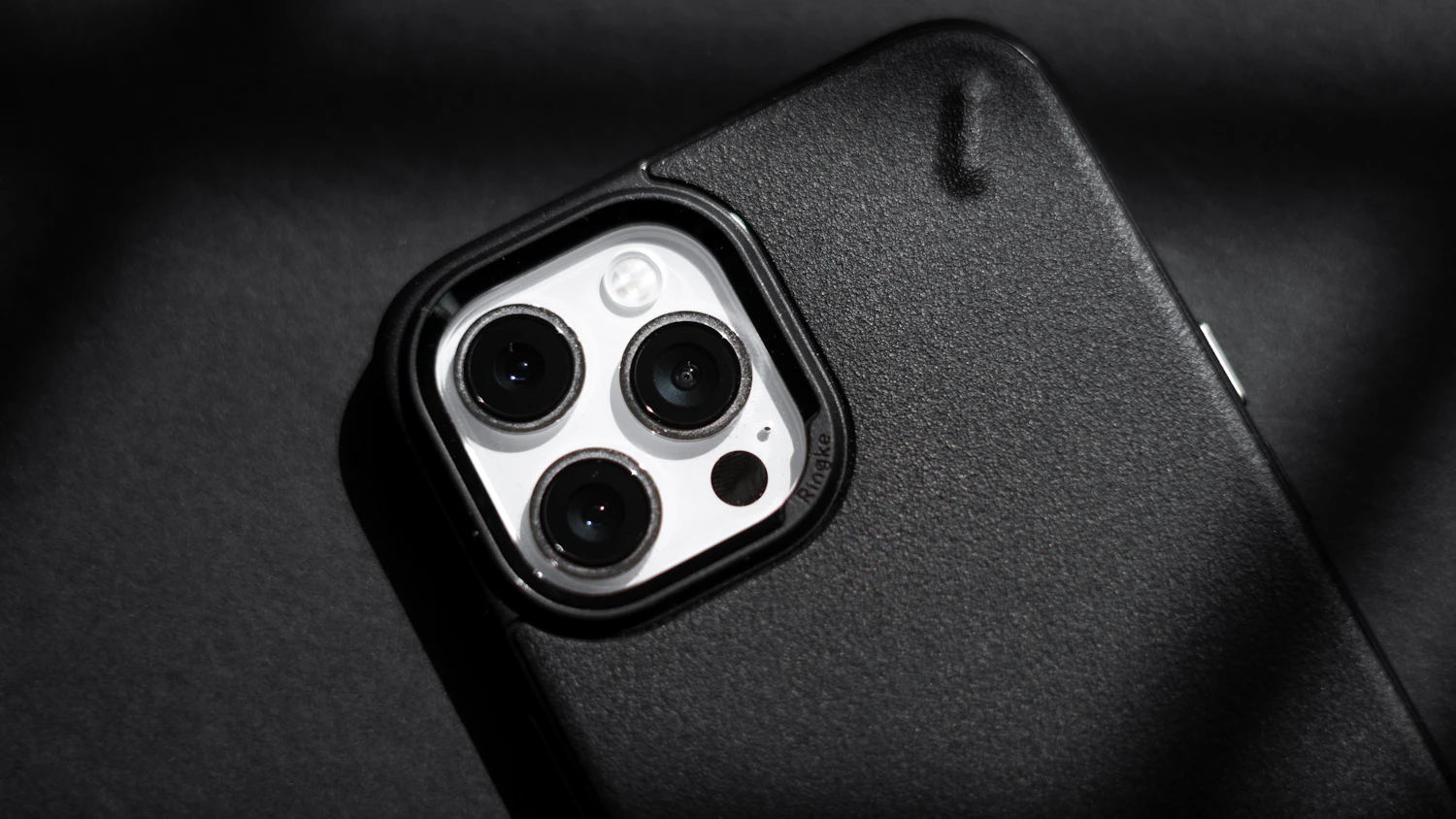 Grip Rib Case in Graphite, close on the raised ring around a three-lens camera